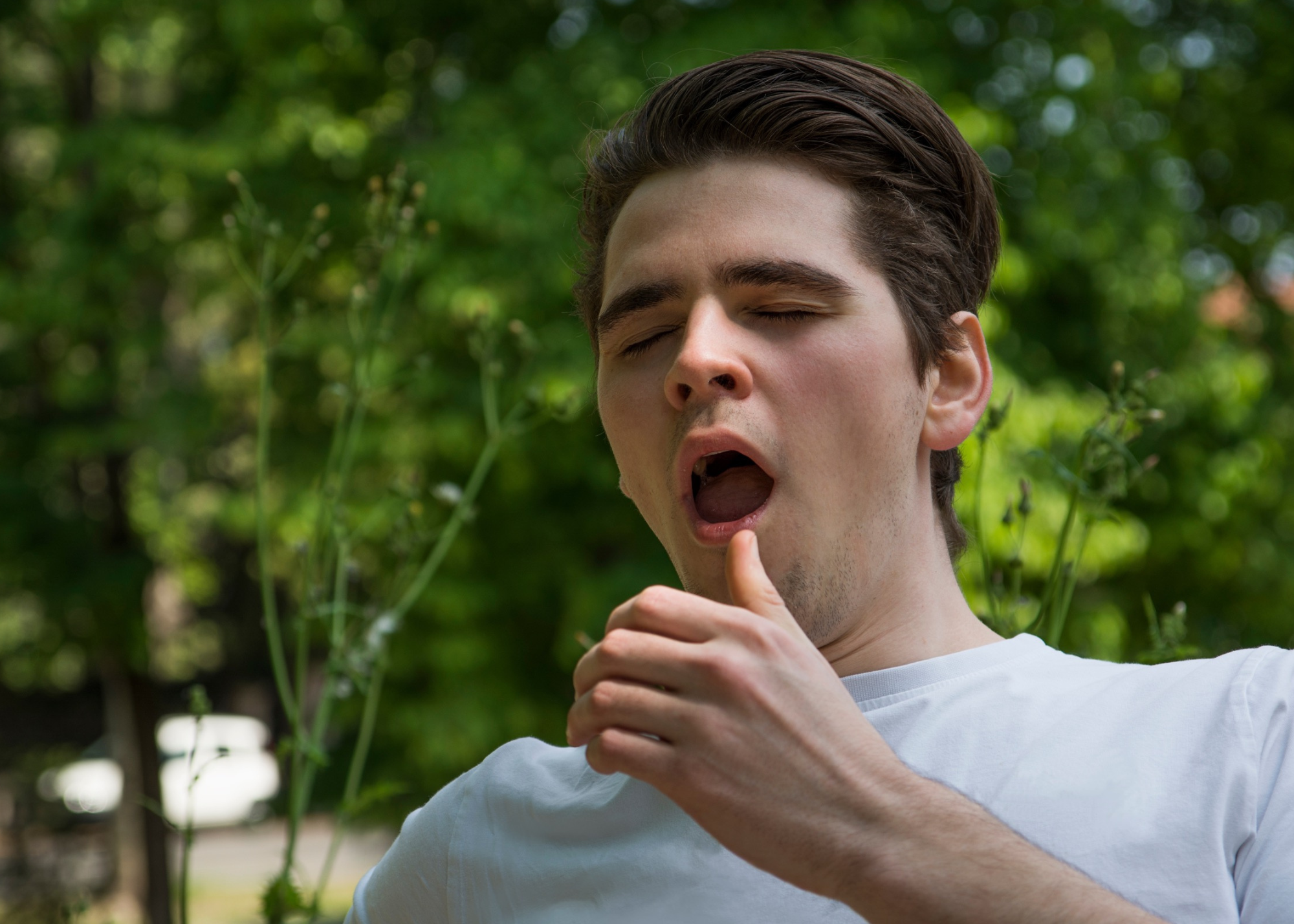 Person outdoors sneezing