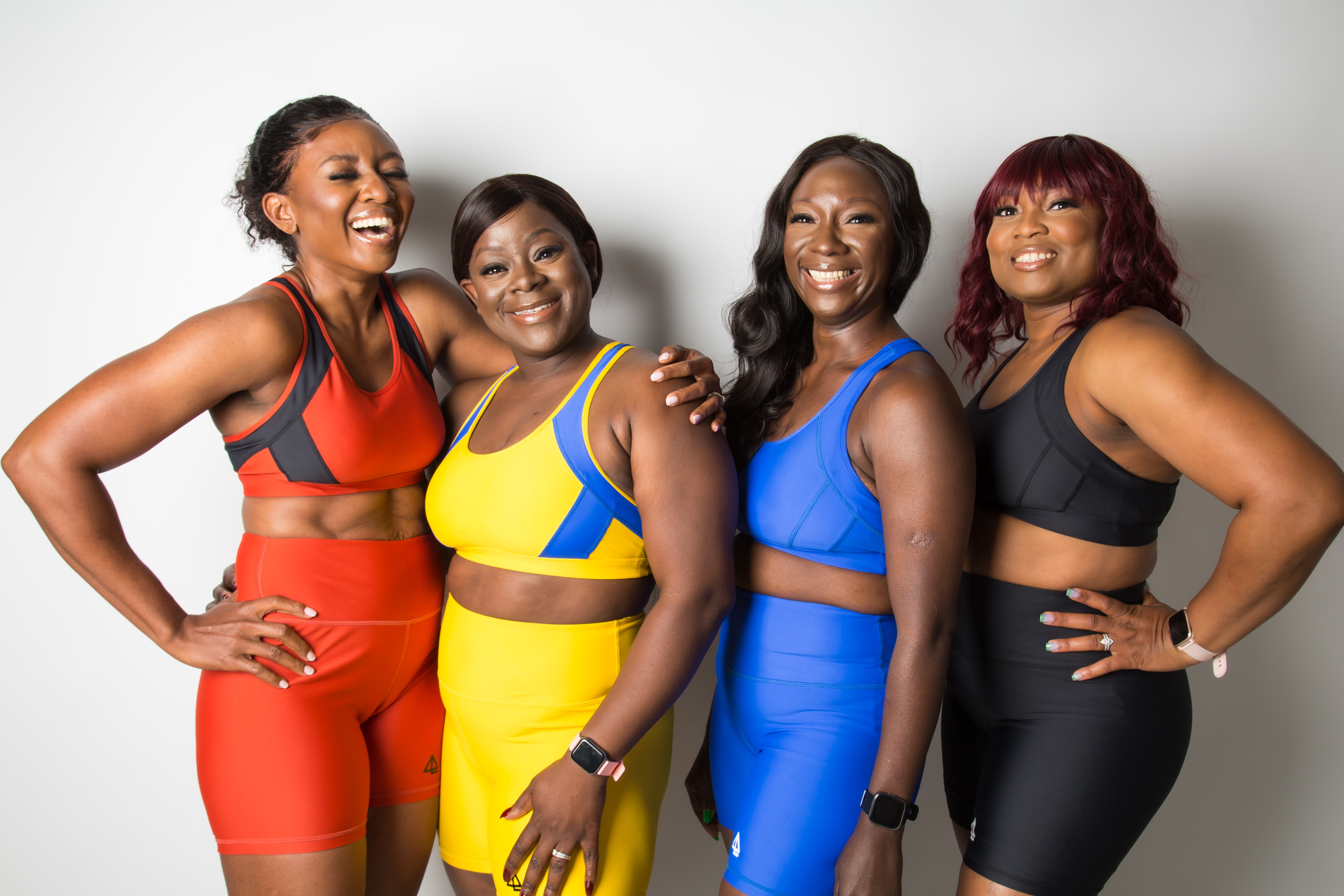 4 smiling people in workout clothes