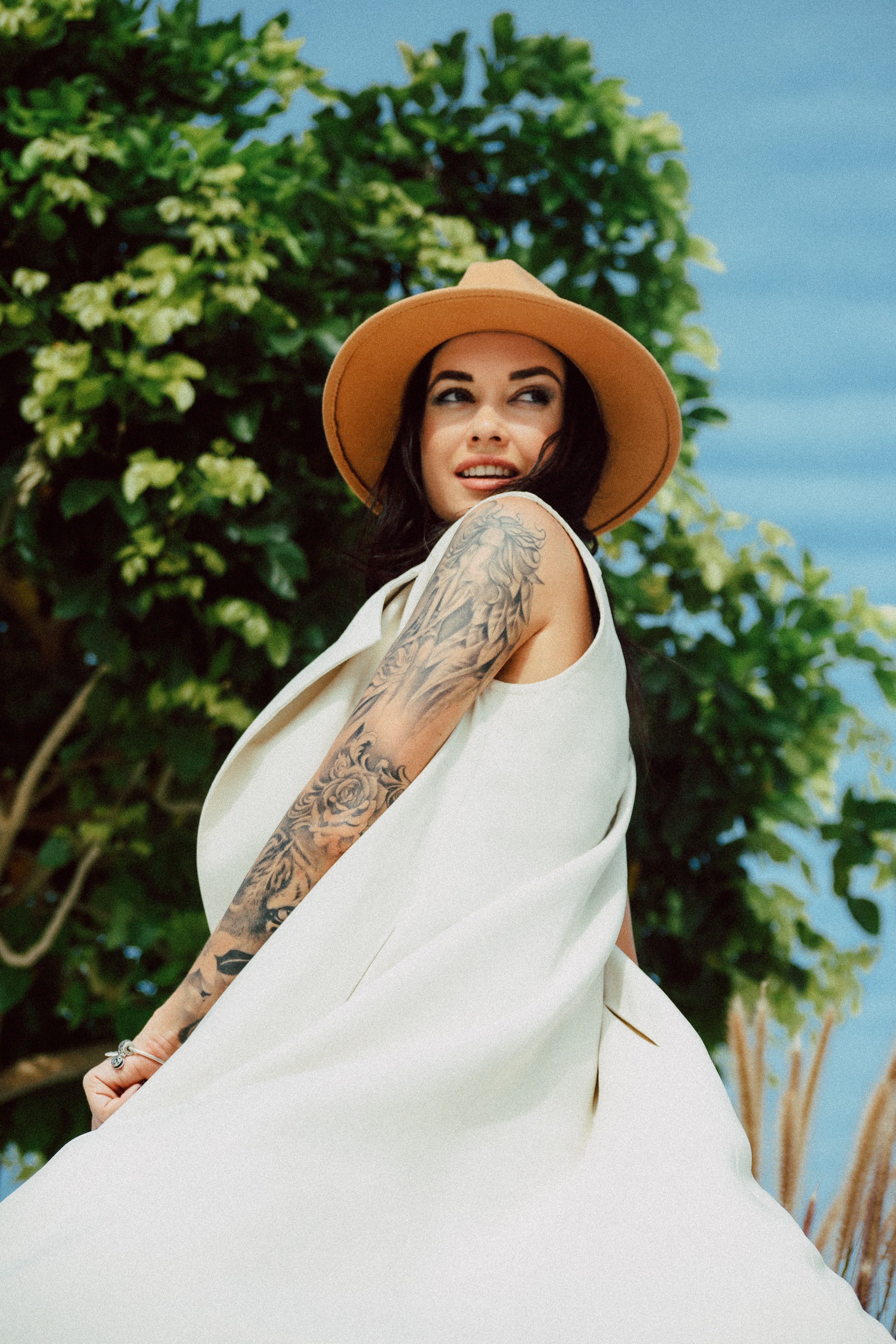 Woman in a dress and hat standing outdoors