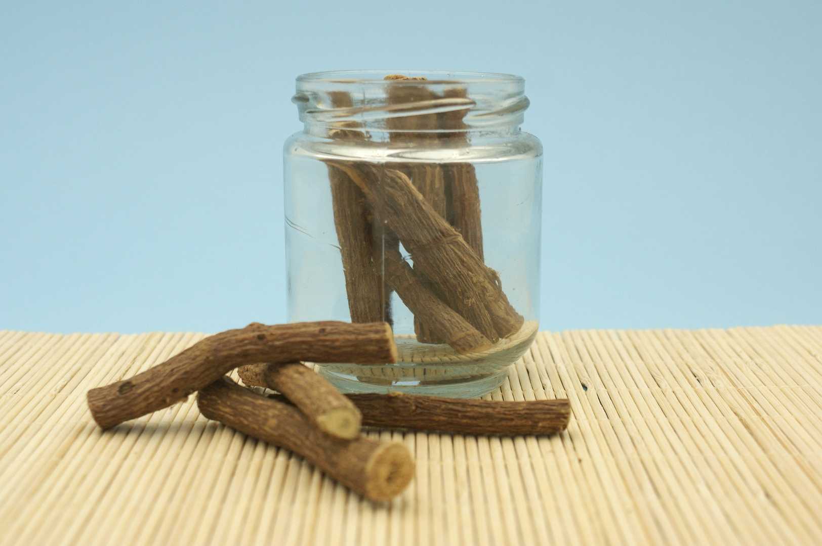 Clear glass jar holding stalks of Licorice Root