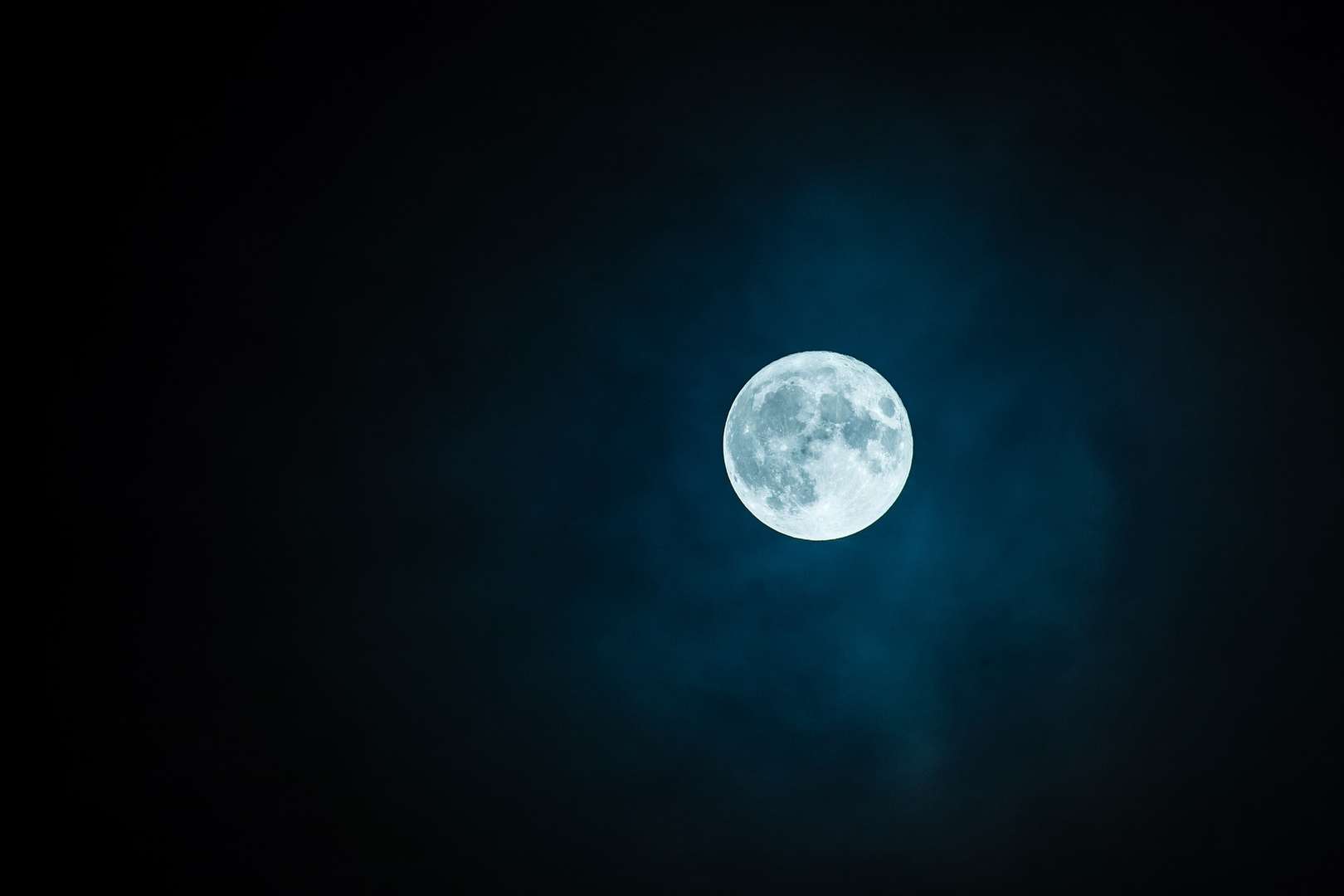 Glowing full moon in dark sky